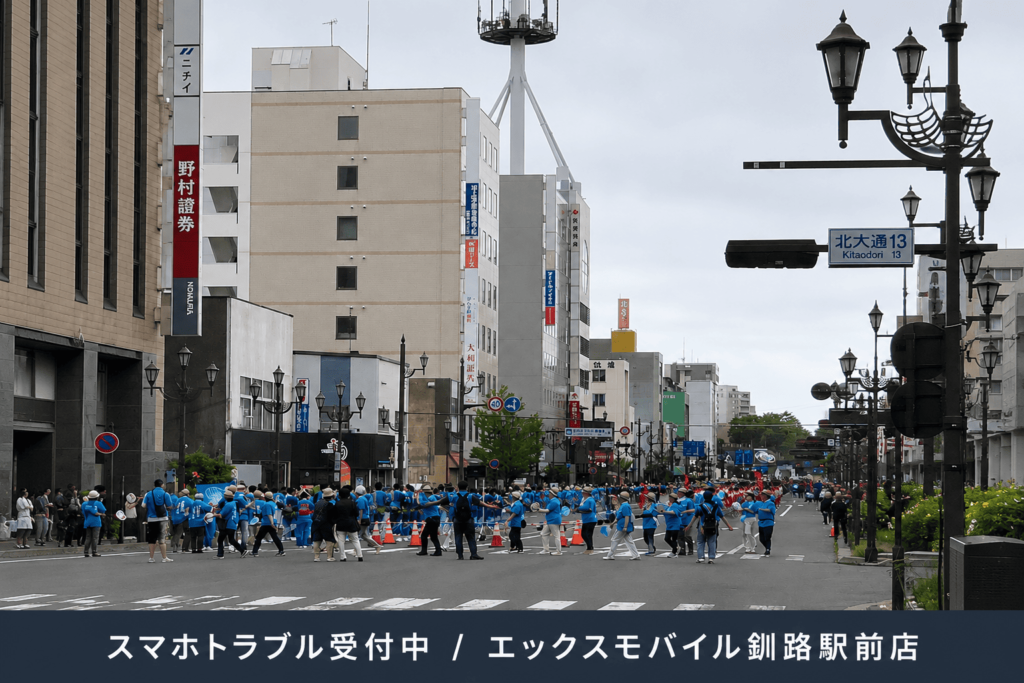 くしろ港まつりのパレードで賑わう北大通とスマホトラブル受付中の案内